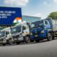 Line-up of Ashok Leyland ICV trucks parked on road with a billboard showing 2025 prices and specs in India